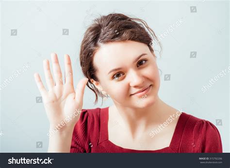 Portrait Of A Young Woman Smiling And Saying Hello Stock Photo