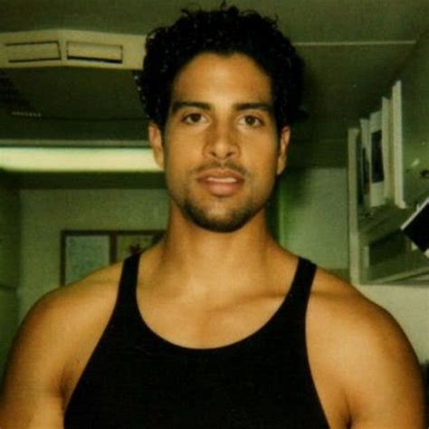 A Man In A Black Tank Top Posing For The Camera