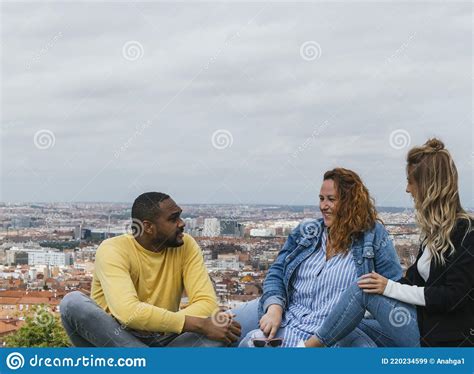 Felices Amigos Interraciales Sentados En Un Parque Hablando Y Riendo Imagen De Archivo Imagen