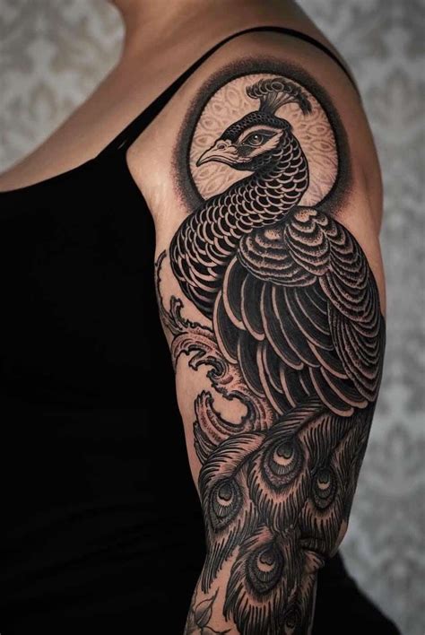 A Woman With A Black And White Peacock Tattoo On Her Arm Showing The Design