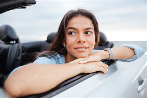 Premium Photo Portrait Of Smiling Woman Sitting In Her Convertible Car On Beach