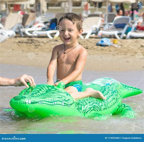 Smiling Grandfather And Grandson Playing And Splashing In The Sea Water