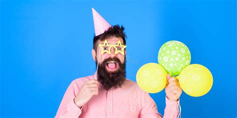 man with beard and mustache on happy face hold air balloons blue background birthday concept