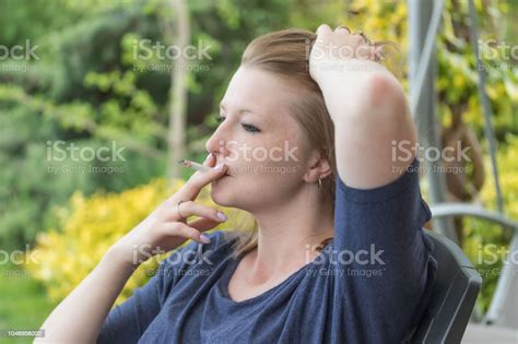 Side View Of Young Woman Smoking Cigarette Stock Photo Download Image