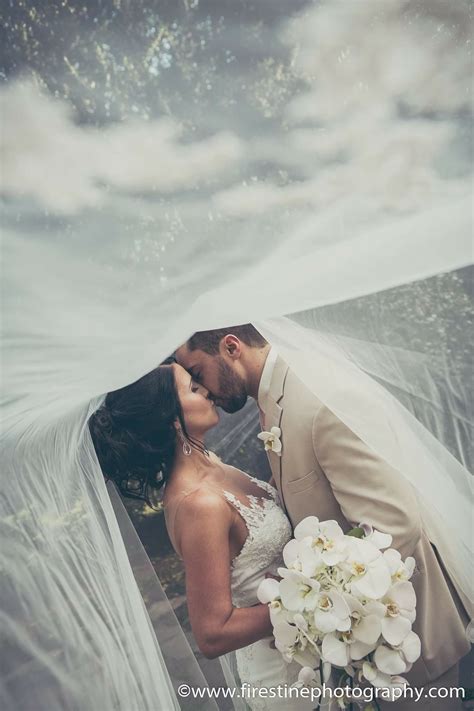 Wedding Photography With The Bride And Groom Under The Veil Kissing
