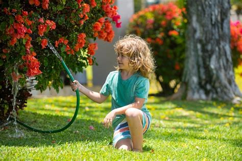 Premium Photo Kids Play With Water Garden Hose In Yard Outdoor