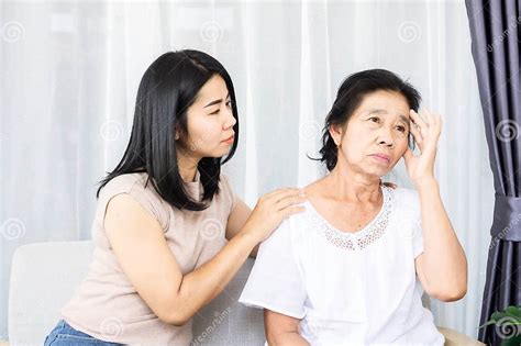 asiática hija consolando apoyando a su deprimido triste madre sentada juntos en casa foto de
