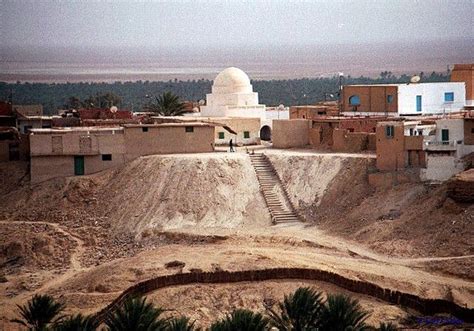 A White Building Sitting On Top Of A Hill Next To A Desert Area With