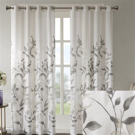 The Curtains In This Living Room Are White And Have Grey Leaves On Them
