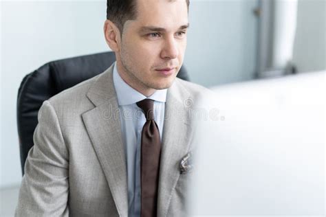 Young Employee Looking At Computer Monitor During Working Day In Office