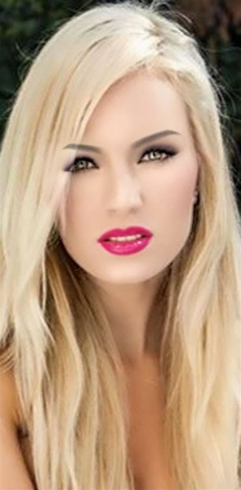 A Woman With Long Blonde Hair And Bright Pink Lipstick On Her Lips Is