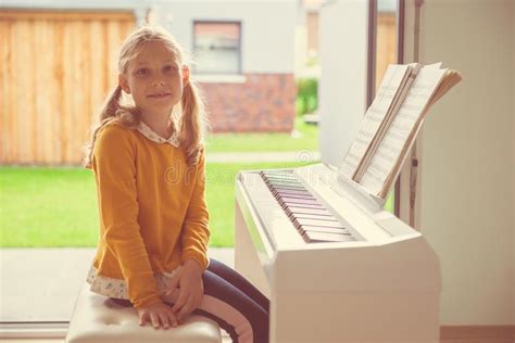 Portrait Of Pretty Little Girl Having Piano Lesson At Modern White E