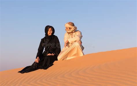 Couple Dressed In Traditional Arab Clothing In Desert Stock Image