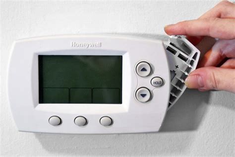 The battery housing is not labeled but it is easy to locate it. How to Change the Battery in a Honeywell Thermostat | eHow
