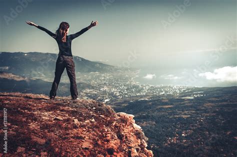 Cheering Young Woman Standing At Sunrise Seaside Mountain Peak Arms