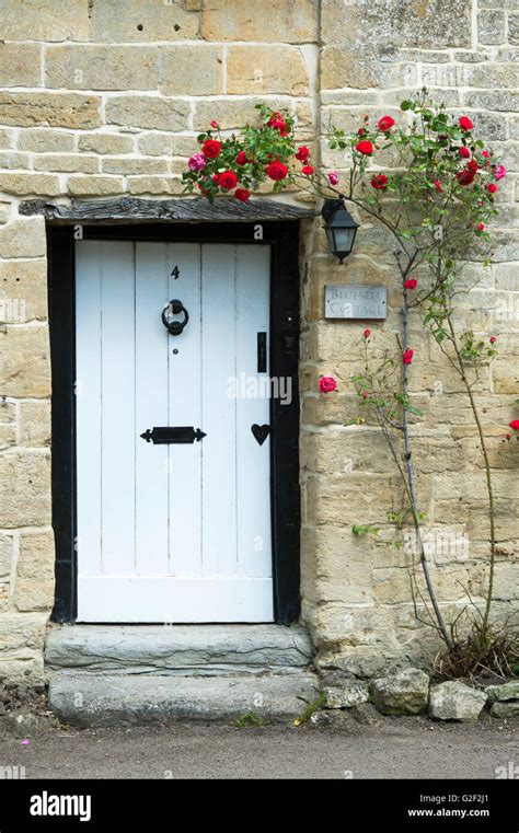 Cotswold Stone Cottage With Red Roses Around The Front Door Stanton