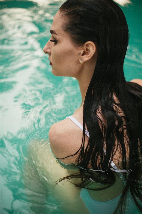 Dark Haired Woman In White One Piece Bathing Suit Swimming In