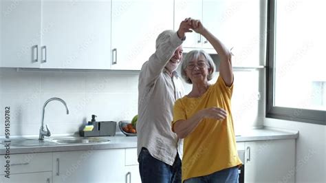 Joyful Active Old Retired Romantic Couple Dancing Laughing In Living Room Happy Middle Aged