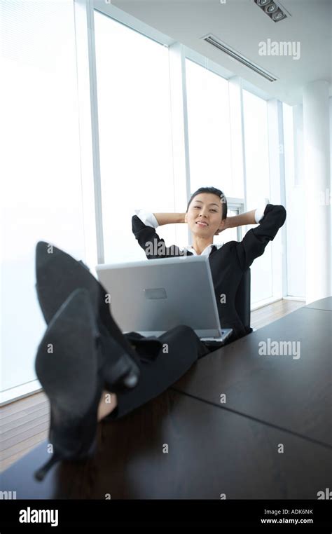 A Businesswoman Putting Her Feet On The Desk Stock Photo Alamy