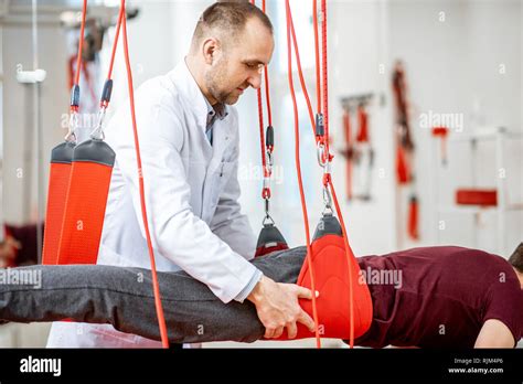 Senior physiotherapist doing treatment to a man with spine problems