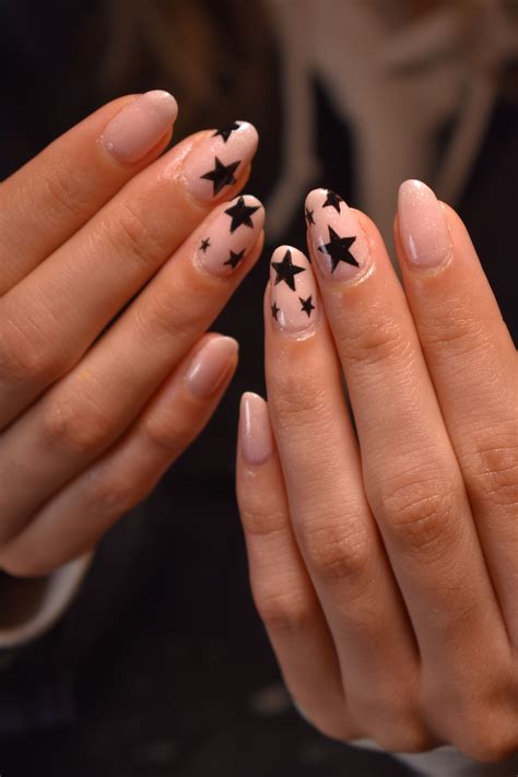 A Woman With Pink And Black Stars On Her Nails