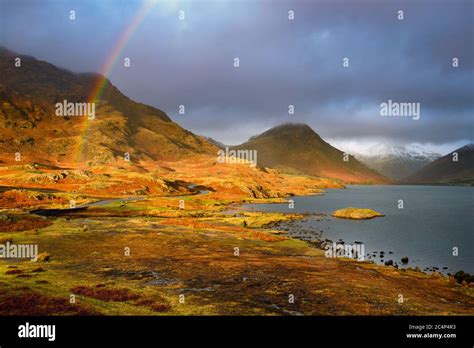 Rainbow In A Dramatic Landscape With Evening Golden Light On Mountains