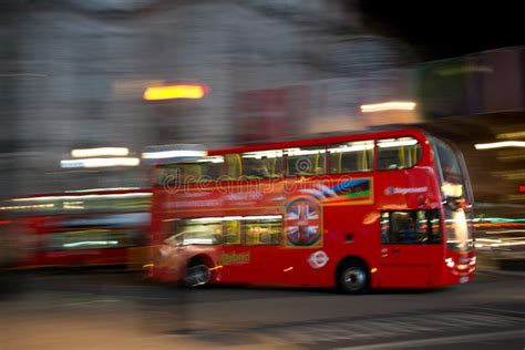 A Red Doubledeck London Bus At Night Seen With Motion Blur Against