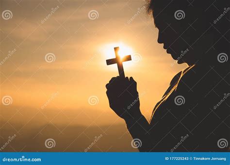 Hands Of A Christian Women Holding A Cross While Praying To God