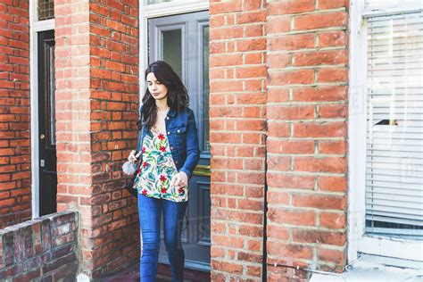 Young woman leaving house - Stock Photo - Dissolve