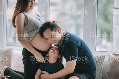 Asian Chinese Man Listening And Leaning On His Wifes Abdomen With His
