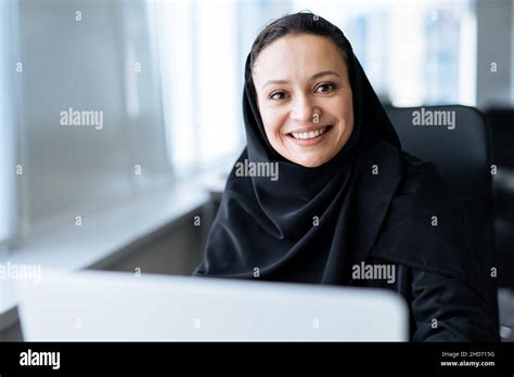 beautiful woman with abaya dress working on her computer middle aged female employee at work in