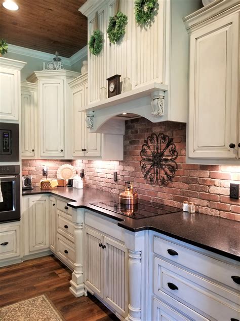 Farmhouse Kitchen With Brick Backsplash And White Cabinets Country