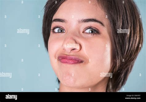 Young Woman Making Funny Face Squeezing Her Face Against Window Glass