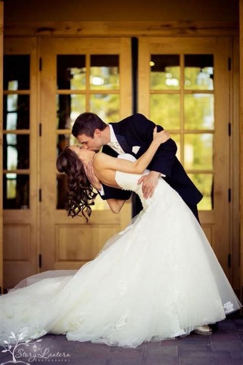 A Bride And Groom Are Kissing In Front Of The Doors At Their Wedding Reception Venue