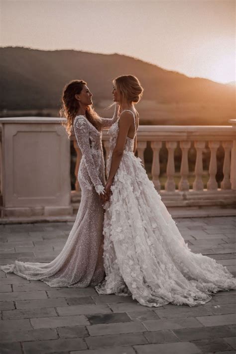 Two Women In Wedding Gowns Standing On A Balcony Looking Into Each Other S Eyes