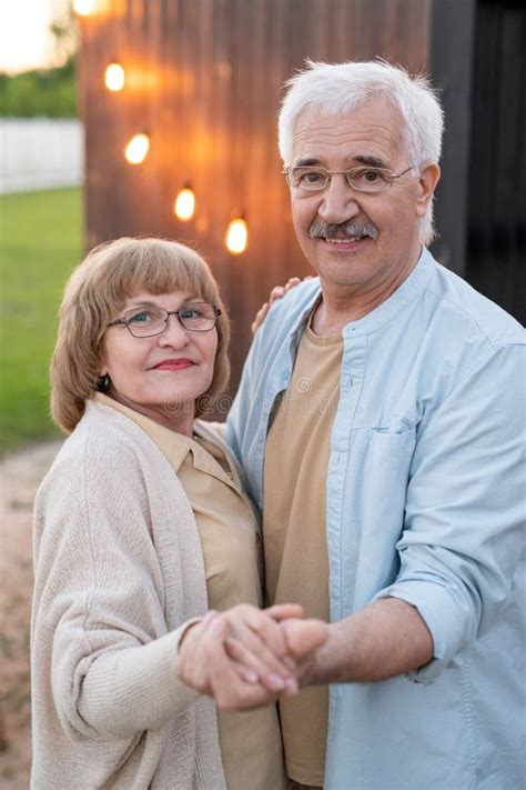 Feliz Anciano Hombre Y Mujer Cogidos De La Mano Frente A La Cámara