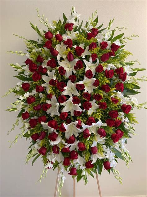 A funeral heart easel of pale yellow carnations edged with lemon leaves tenderly holding five ivory roses trimmed with ivory ribbon. Funeral Standing Spray #14 - Kimanh Flowers