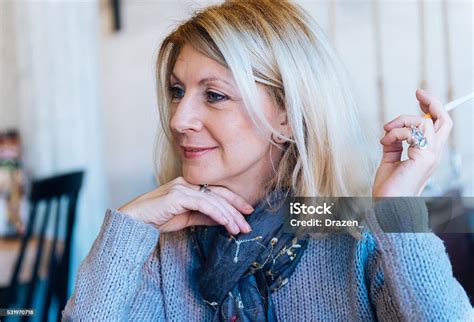 Portrait Of Beautiful Blonde Mature Woman In Smoking Cigarette Stock