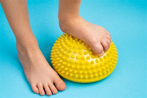 Childrenand X27s Feet With A Yellow Balancer On A Light Blue Background