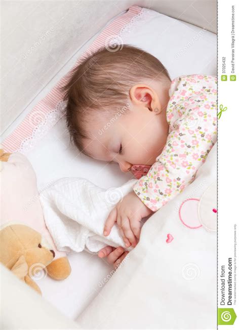 Baby Girl Sleeping In A Cot With Pacifier And Toy Stock
