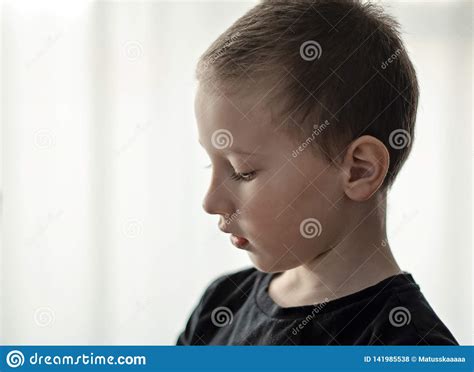 Close Up Portrait Of Depressed Young Pre School Boy In Black T Shirt