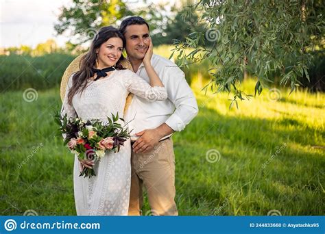 Cute Newlyweds Hugging And Smiling In A Green Park Portrait Of The