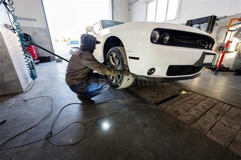 Mechanic In Service Repair Station Working With Muscle Car Man Worker Jacks Up The Car To