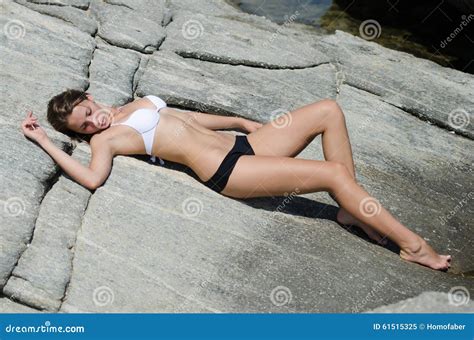 Sunbathing On Rocks On The Secluded Beach Light Steaming Through The