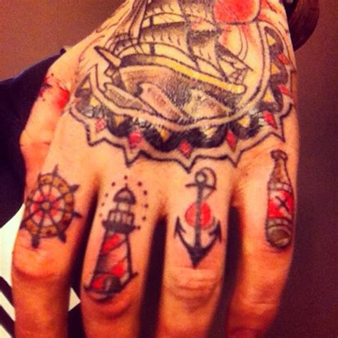 The anchor tattoo has remained popular for many years. Ship wheel lighthouse anchor finger tattoo | Hand tattoos ...