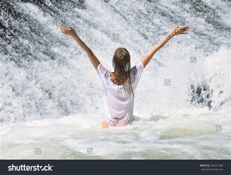 Young Beautiful Woman In White Wet Dress Standing In The Water At The