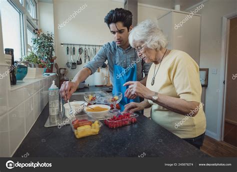 Teenage Boy Making Fruit Compote His Grandmother Kitchen Her Home Stock