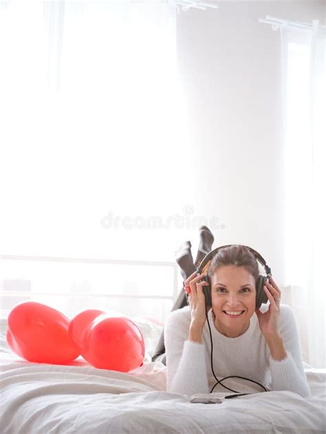 Woman Listening To Music In Bed With The Mobile With Happy Expression