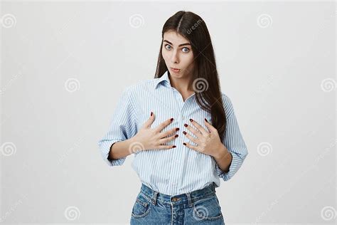Portrait Of Attractive Female Model With Impressed Expression Holding Her Breast With Both