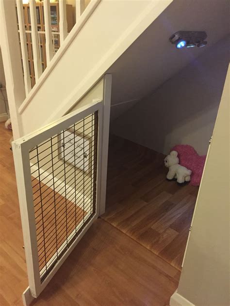A Dog Gate In The Corner Of A Room Next To A Stair Case With A Stuffed